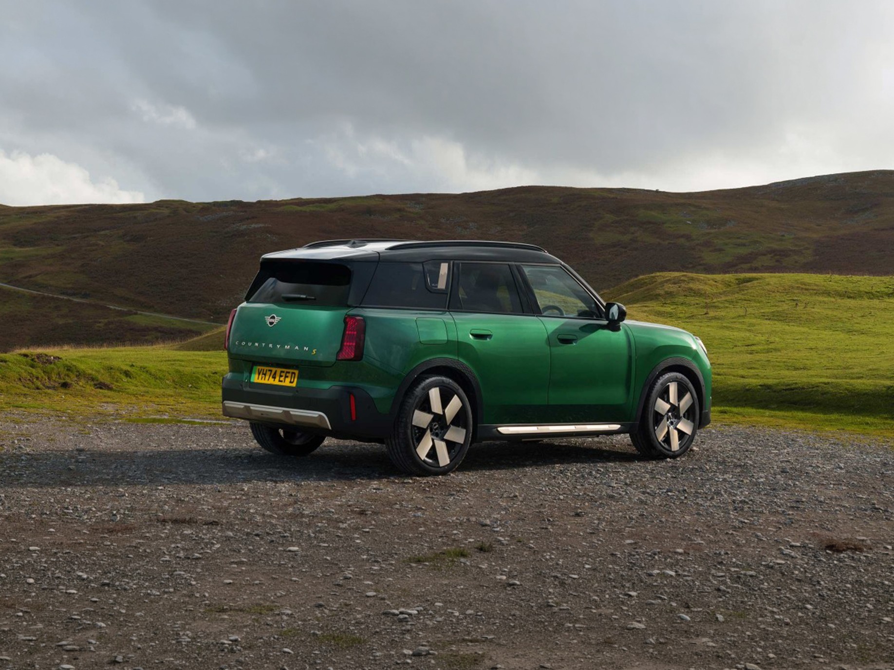 Front view of the all-electric MINI Countryman in Midnight Black and Vibrant Silver Roof on a street.